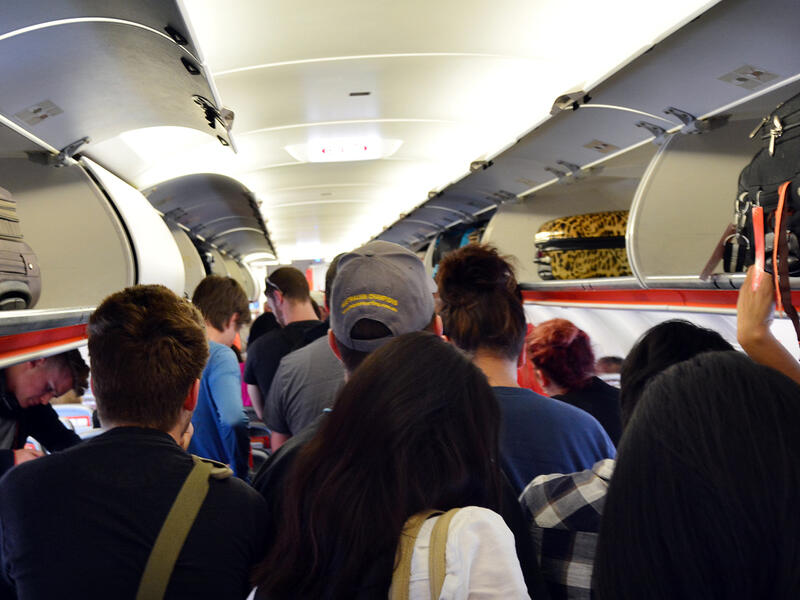 passengers standing in aisle airplane