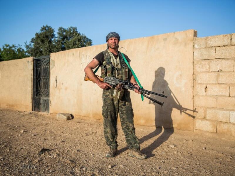 26-year-old ‘Hewal Cudi’ poses with a machine gun just outside Tal Tamr on April 19, 2015.
