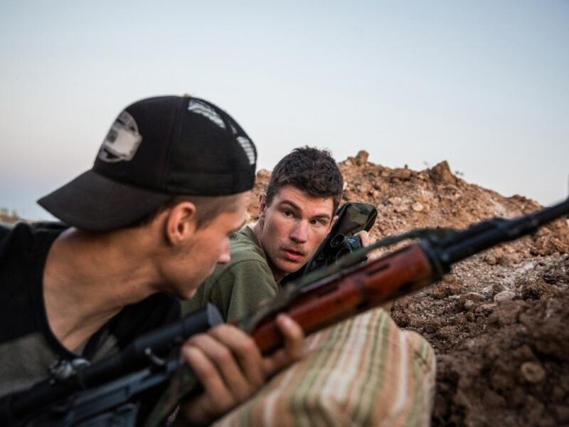 Ex-US marines aged 23 and 24 from the US, nicknamed by Kurdish fighters as ‘Hewal Agir’ (R) and ‘Hewal Agit’, guard a position outside Tal Tamr during clashes with Daesh fighters on April 17, 2015.