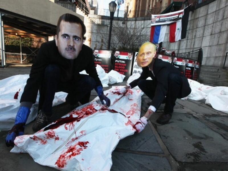 Activists dress up as the Syrian and Russian presidents