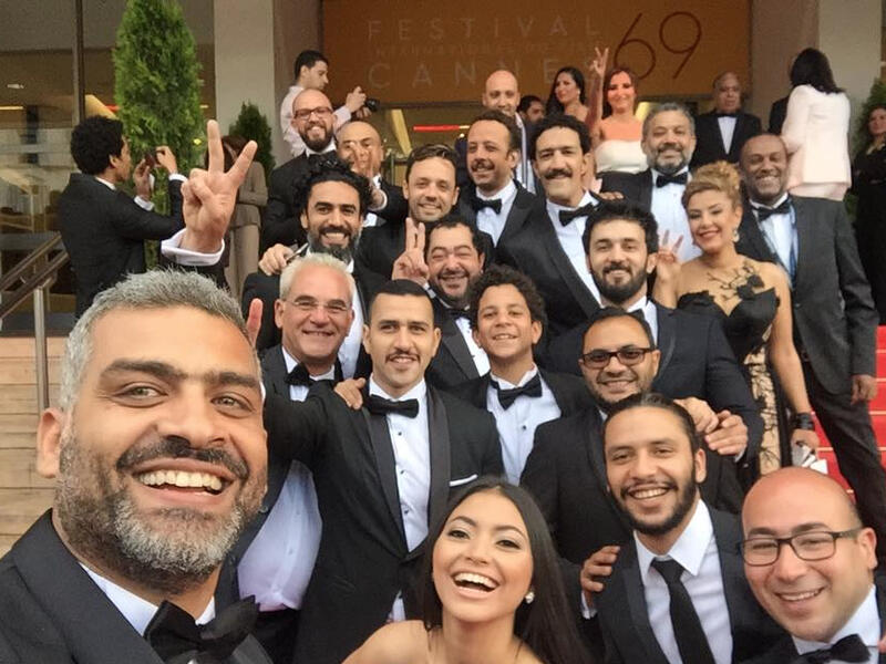 Egyptian actor Hany Adel (L) takes a selfie on the red carpet with cast members ahead of the screening of the film "Eshtebak" (Clash) during the 69th Cannes Film Festival in Cannes, France, May 12, 2016. (Facebook)