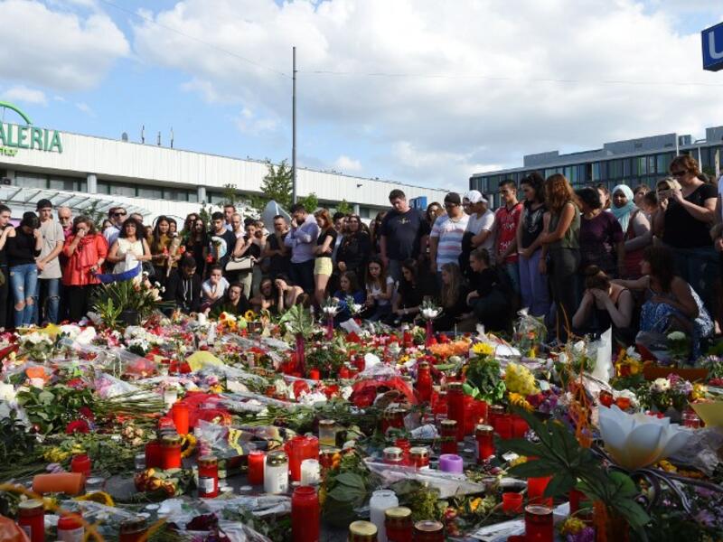 People mourn at a memorial on July 24, 2016 in front of the Olympia Einkaufszentrum shopping center in Munich, Germany, where an 18-year-old German-Iranian student shot and killed nine people. (AFP/Christof Stache)