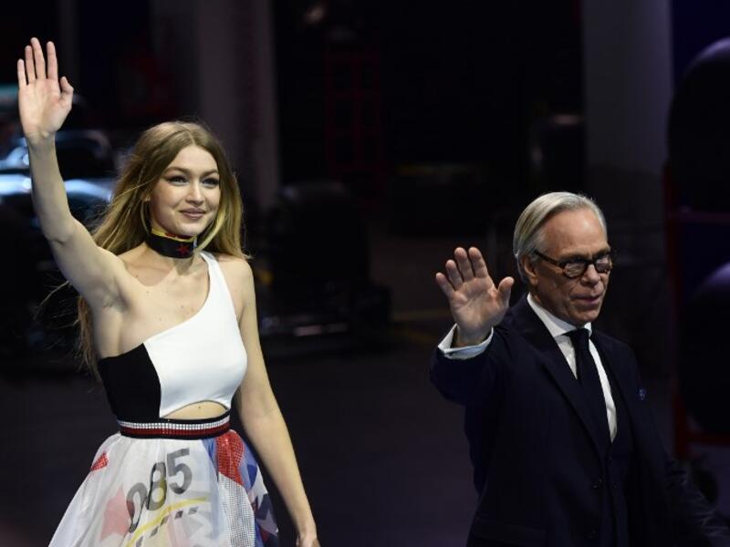 Gigi opened Sunday night’s show with a pair of blue and black leather racing leggings and a Hilfiger bandeau top, and closed in a long diaphanous layered maxi dress with racing logo prints. (Source: MIGUEL MEDINA - AFP)