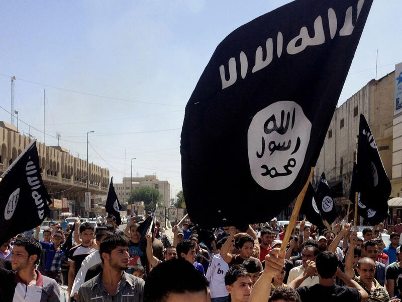 ISIS supporters wave their infamous black flag in a demonstration. (AFP/File)