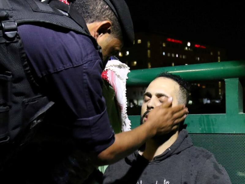 Jordanian riot police attend to a protester who passed out during a demonstration outside the prime minister's office in the capital Amman late on June 3, 2018. 
Khalil MAZRAAWI / AFP