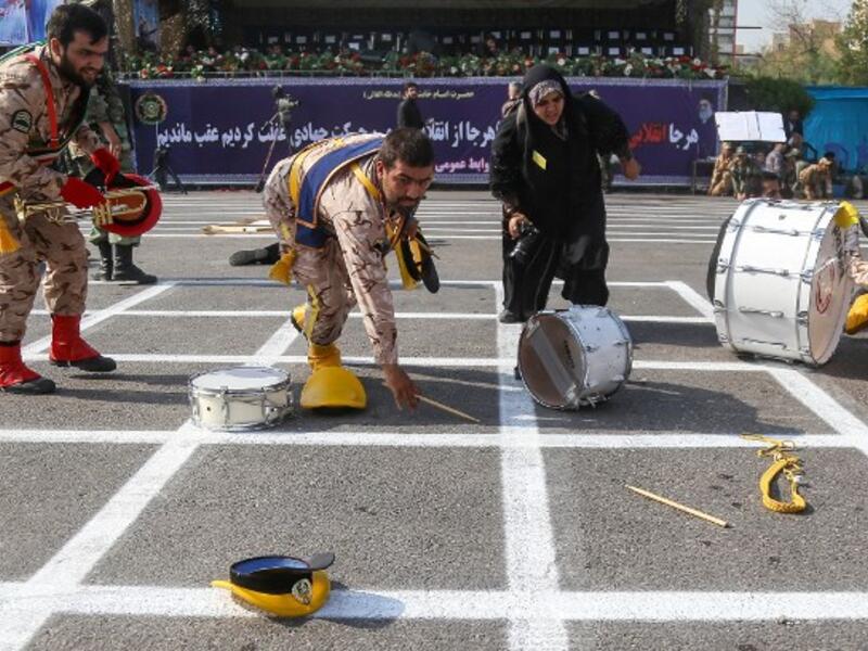 September 22, 2018 in the southwestern Iranian city of Ahvaz shows members of an Iranian military marching band reaching for their fallen instruments at the scene of an attack on a military parade that was marking the anniversary of the outbreak of its devastating 1980-1988 war with Iraq. (MORTEZA JABERIAN / ISNA / AFP)