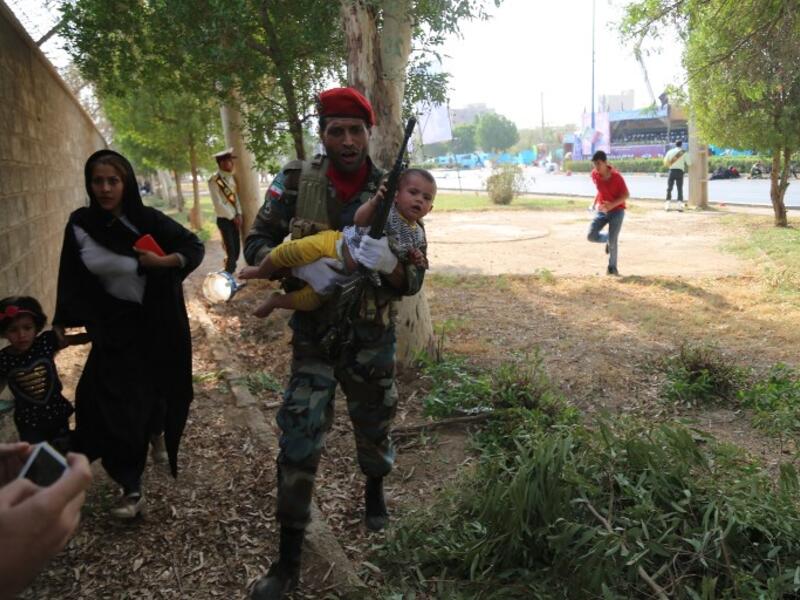 An Iranian soldier carrying a child at the site of an attack on a military parade in the southwestern Iranian city of Ahvaz on September 22, 2018. (Mehdi Pedramkhou / AFP / MEHR NEWS)