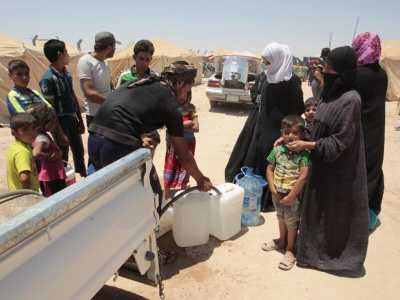 Iraqi families receive water at a camp for internally displaced people after fleeing Fallujah during the military operation to retake the city from Daesh. (AFP/File)