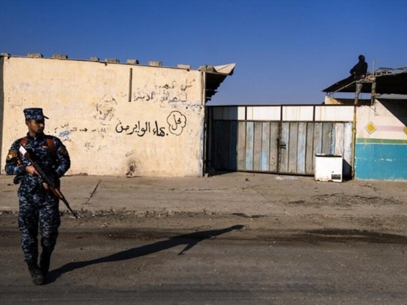 An Iraqi policeman stands guard as the Iraqi army search for booby-trapped buildings in eastern Mosul on 16 January. (AFP/File)