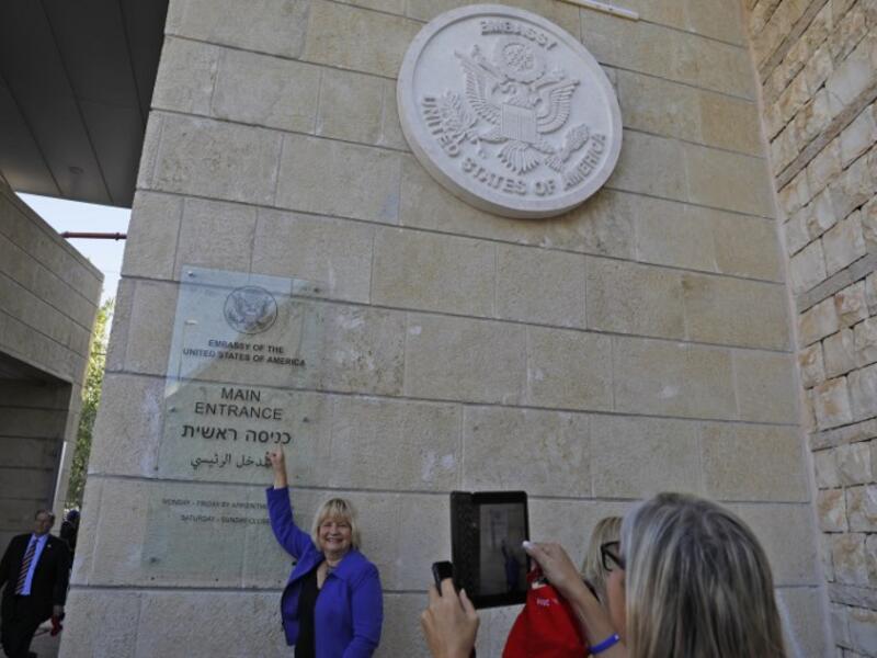A woman poses for a picture next to an inauguration plaque during the opening of the US embassy in Jerusalem on May 14, 2018. Palestinian anger and exuberant praise from Israelis over President Donald Trump's decision tossing aside decades of precedent.
Menahem KAHANA / AFP