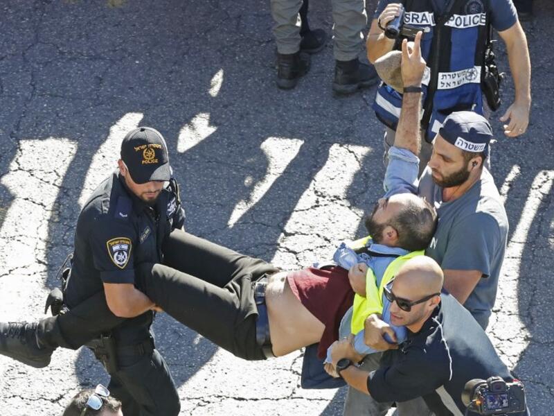 Members of the Israeli security forces arrest a protester wearing a yellow vest, during demonstrations against the rising cost of living on December 14, 2018.
JACK GUEZ / AFP