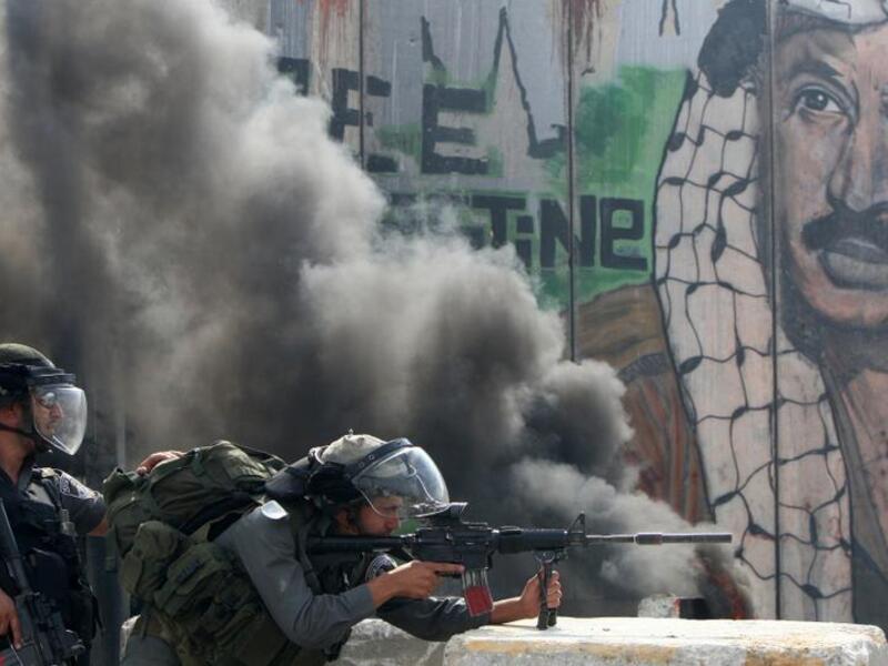 Israeli soldiers attack Palestinian protestors at a checkpoint outside occupied Jerusalem (AFP)