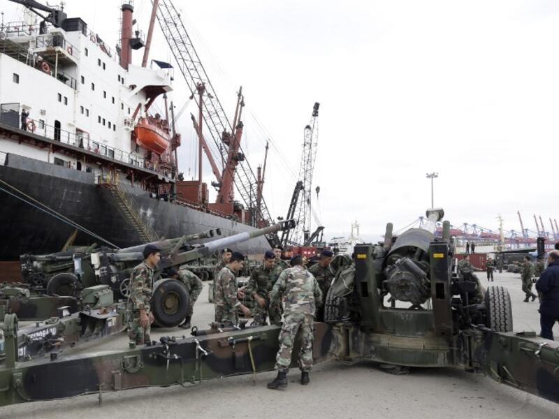 Lebanese soldiers stand next to M198 155mm howitzers upon the arrival of a shipment of US weapons at the Beirut port on February 8, 2015. (AFP/Anwar Amro)