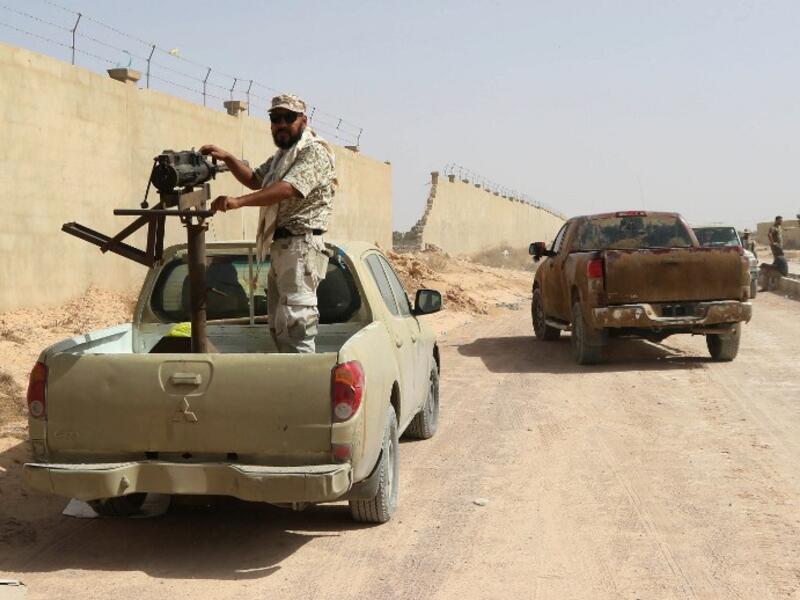 A fighter from forces loyal to Libya's Government of National Unity (GNA) stands on a truck mounted with a machine gun as he holds a position in Sirte during an operation to recapture the coastal city from Daesh, on July 2, 2016. (AFP/Mahmud Turkia)