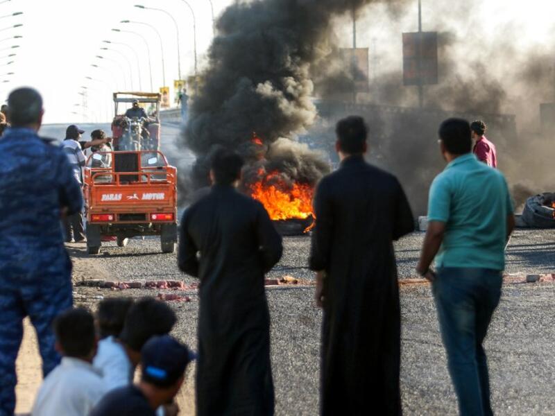 Iraqi protesters, who are demonstrating against corruption and lack of basic services, burn tires as they block the main road between the centre of the southern city of Basraon September 2, 2018. 
Haidar MOHAMMED ALI / AFP