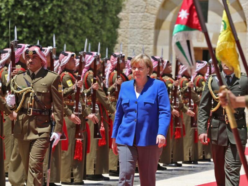 German Chancellor Angela Merkel reviews an honour guard upon her arrival at the Jordan Royal Palace in Amman June 21, 2018. (AFP/Khalil Mazraawi)