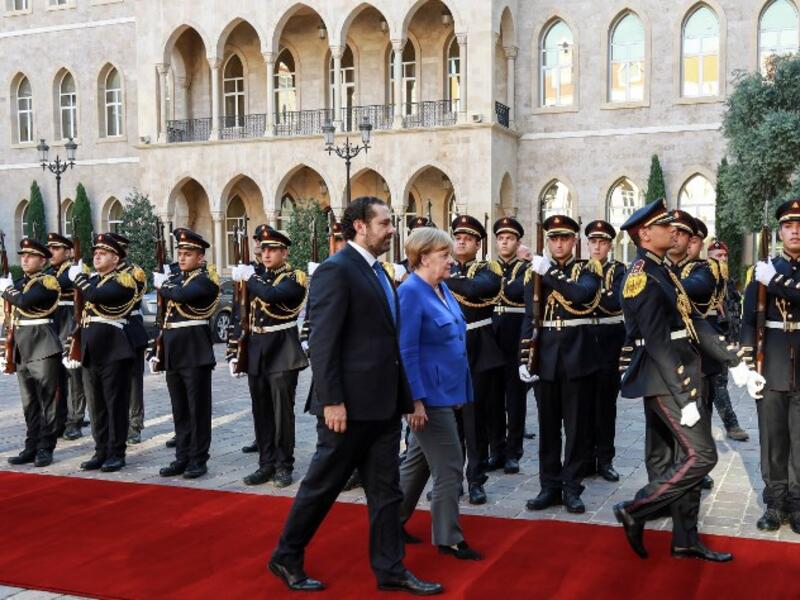 Lebanese Prime Minister Saad Hariri (L) receives German Chancellor Angela Merkel (C) inspect an honour guard as she arrives at the prime minister's office in the Lebanese capital Beirut, June 21, 2018. (AFP/Anwar Amro)