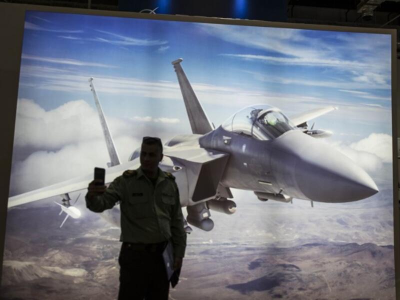 A Palestinian presidential guard takes selfie in front of a F15 jet fighter poster during Egypt’s first Service Defence Exhibition in Cairo on December 3, 2018, at the International Exhibition Center. 
Khaled DESOUKI / AFP