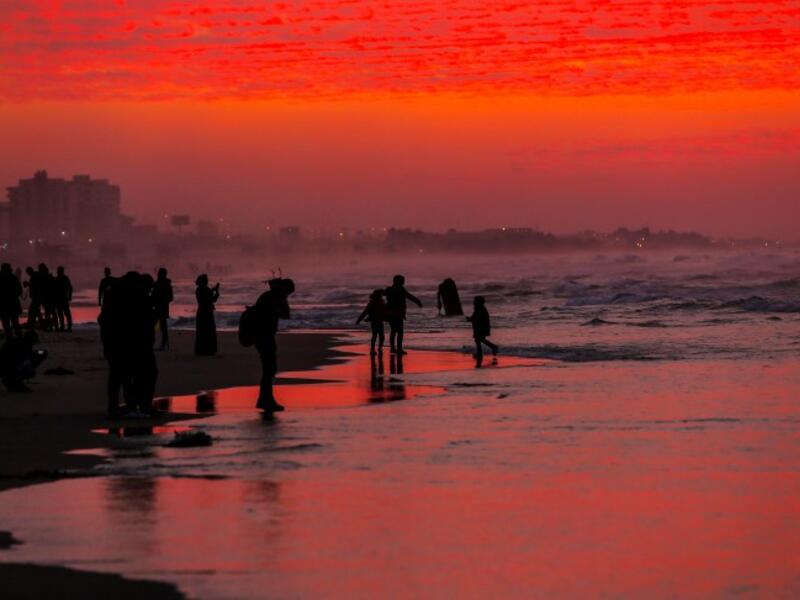Palestinian people walk on the beach at sunset west of in Gaza city on December 31, 2018. 
MAHMUD HAMS / AFP


