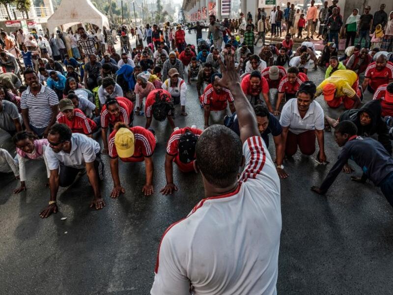 People take part in an exercise on a street in Addis Ababa on February 3, 2019 during the third Car Free Day promoted by local NGOs and the Ethiopian Government to appeal to a healthy life style and a less air pollution of the capital city. 
EDUARDO SOTERAS / AFP