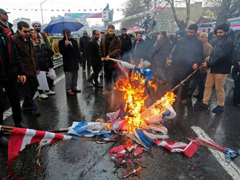 Iranians burn flags of Israel and the United States during commemorations of the 40th anniversary of Islamic Revolution in the capital Tehran on February 11, 2019. 
ATTA KENARE / AFP