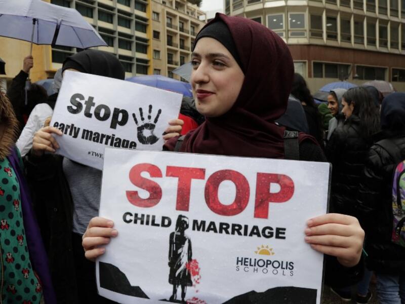 A Lebanese woman hold a placard as she participates in a march against marriage before the age of 18, in the capital Beirut on March 2, 2019. 
ANWAR AMRO / AFP