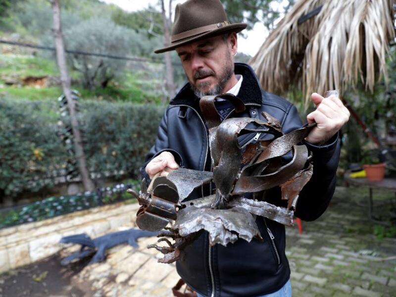Lebanese Artist Charles Nassar inpsects his sculptures made out of artillery shrapnels in the village of Remhala, south of Beirut, on March 7, 2019.
JOSEPH EID / AFP