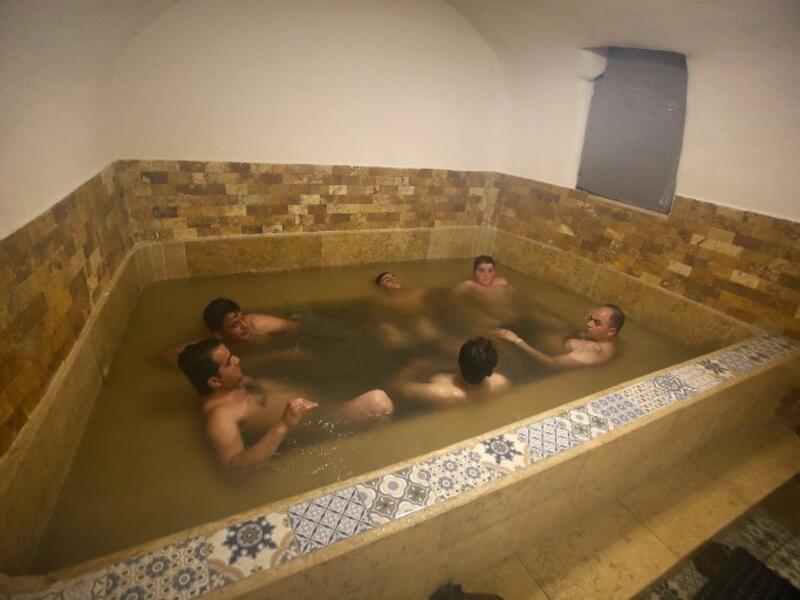 Men sit together in a pool of water at the first traditional Turkish bath (Hammam) opening in the occupied Palestinian West Bank city of Hebron on March 11, 2019. 
HAZEM BADER / AFP