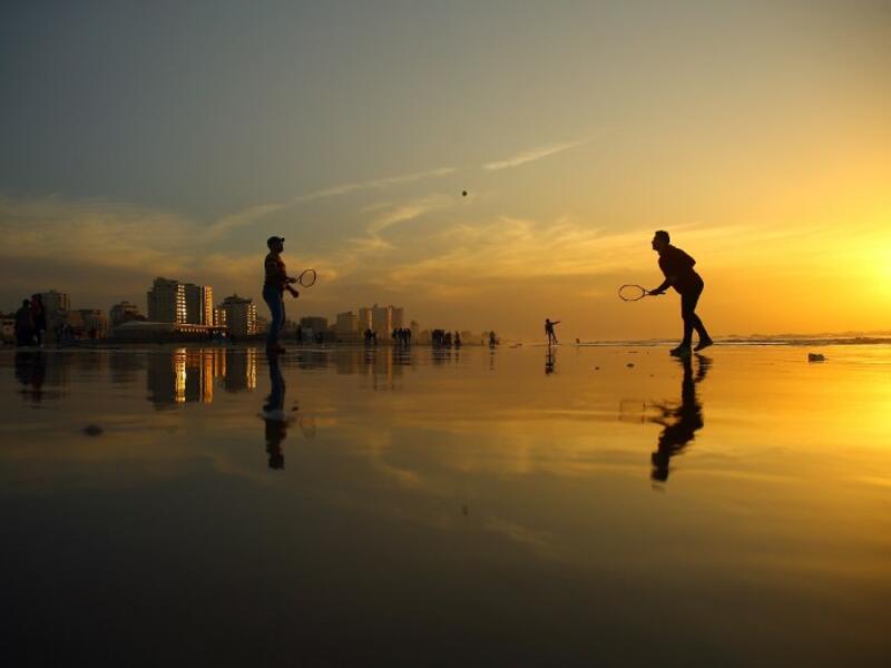 Palestinians play tennis on the beach during the sunset in Gaza City on January 11, 2017. (AFP/MOHAMMED ABED)