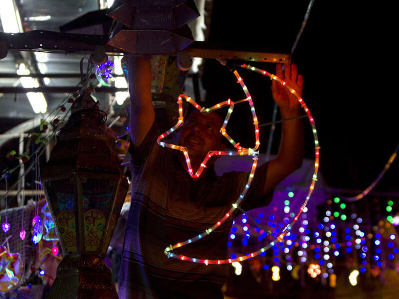 A Palestinian man decorates his shop near the entrance of the Al-Aqsa mosque compound, in the old city of Jerusalem, in preparation for Ramadan. 
AFP/ File Photo