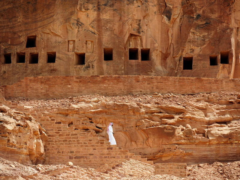 A Saudi man walking near ancient tombs at the Khuraiba archaeological site near Saudi Arabia’s northwestern town of al-Ula. (AFP)