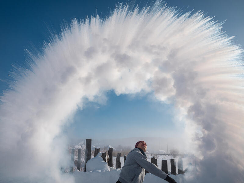 A man from the ladle pours the boiling water up into the sky in an arc in freezing weather. (Shutterstock/ File Photo)