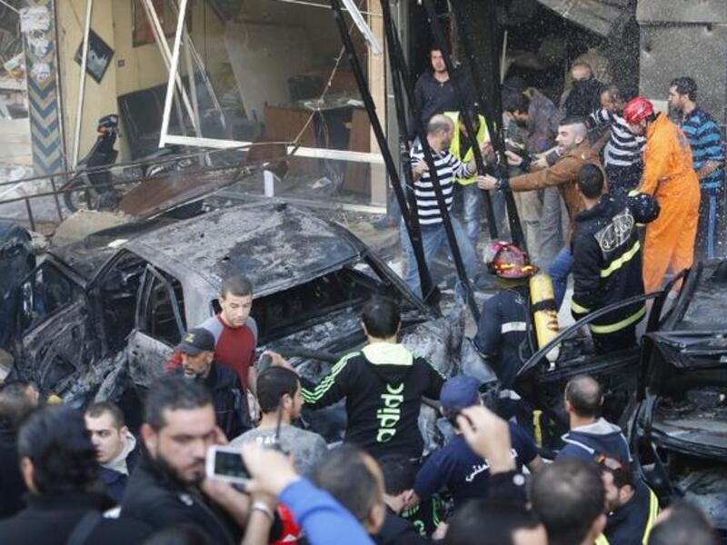 Rescue teams and local residents gather at the scene of a car bomb explosion in Beirut's southern suburb of Haret Hreik on January 21, 2014. [AFP]