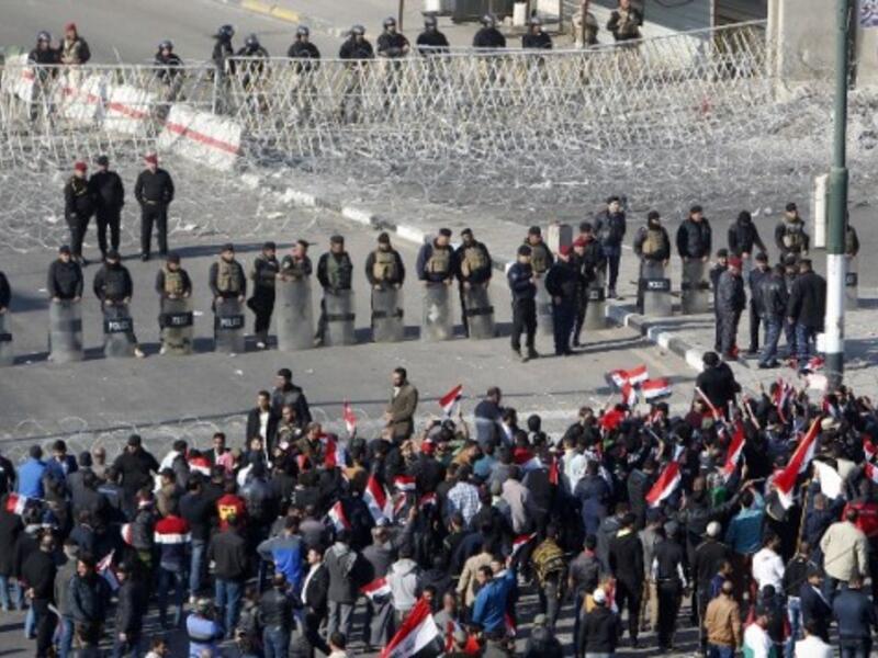 Iraqi security forces stand guard as supporters of the Sadrist movement gather during a demonstration in Baghdad. (AFP/File)