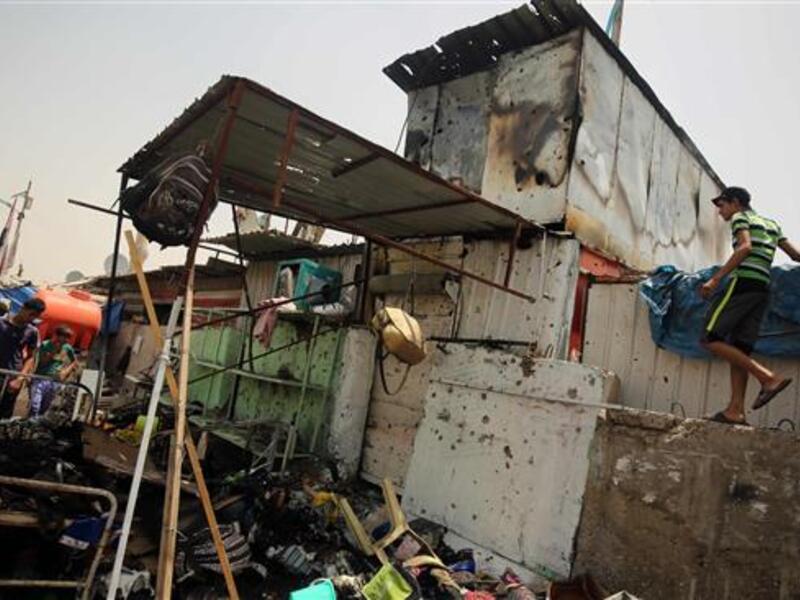 This May 11, 2016 photo shows people looking at the damage following a car bomb in Baghdad. (AFP/File)