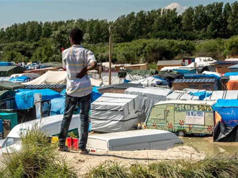 A refugee looks at the “Jungle” camp for in Calais on June 24, 2016. (AFP/File)