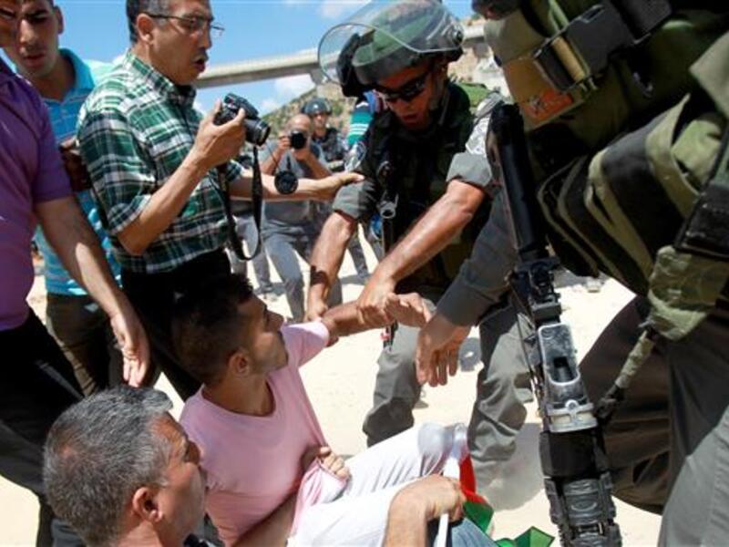Israeli forces scuffle with Palestinian protesters during clashes following a demonstration against land confiscation for Israel's apartheid barrier in the West Bank. (AFP/File)