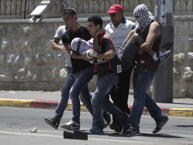 A Palestinian injured protester is carried by comrades during clashes with Israeli police in Shuafat neighborhood in Israeli-annexed Arab East Jerusalem on July 2, 2014. (AFP/File)