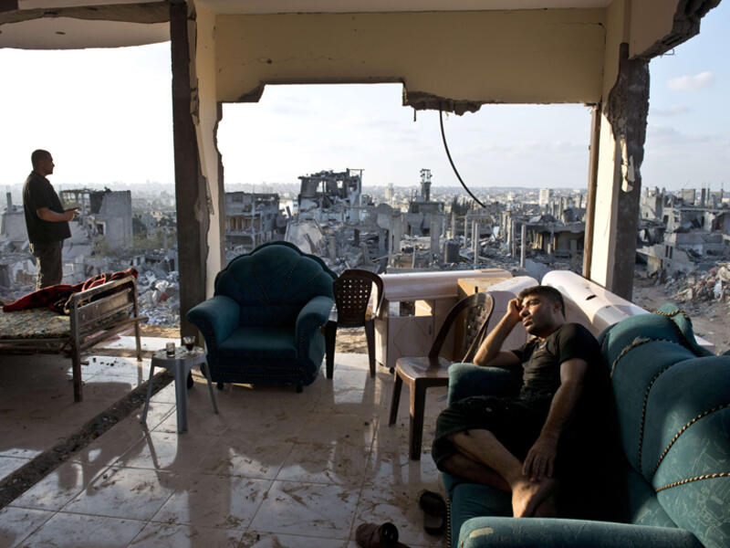 Palestinians from Gaza sit amidst the aftermath and rubble of Israeli airstrikes. (AFP/Roberto Schmidt)