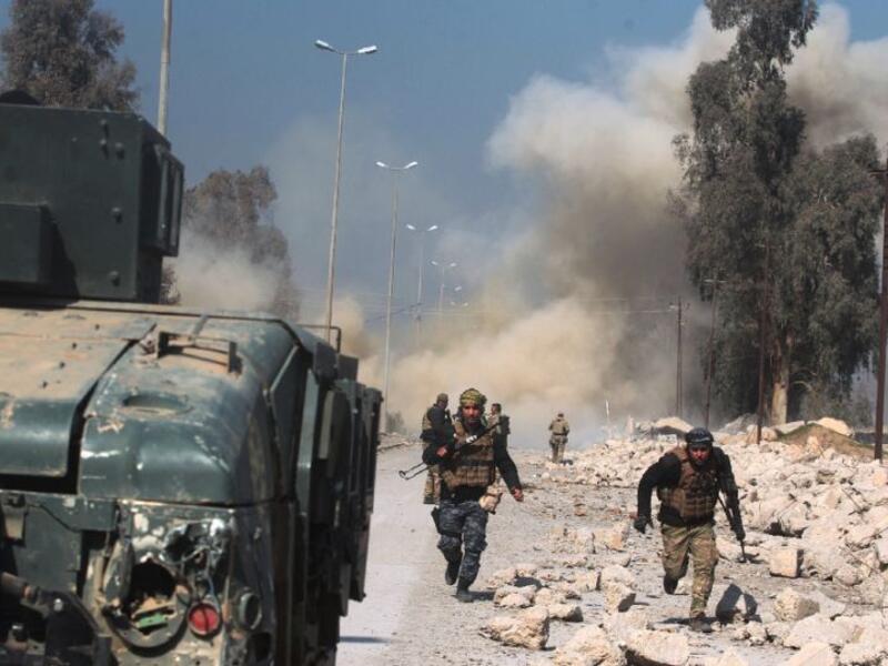 Smoke billows in the background as Iraqi forces advance on Mosul airport during an offensive. (AFP/File)