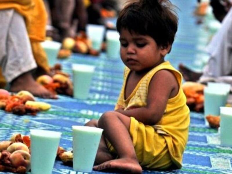 Pakistan's Karachi: Children congregate in a public tent setting to mark the break of fast food stuff, prepared for Iftar for fellow Pakistani 
Muslims.