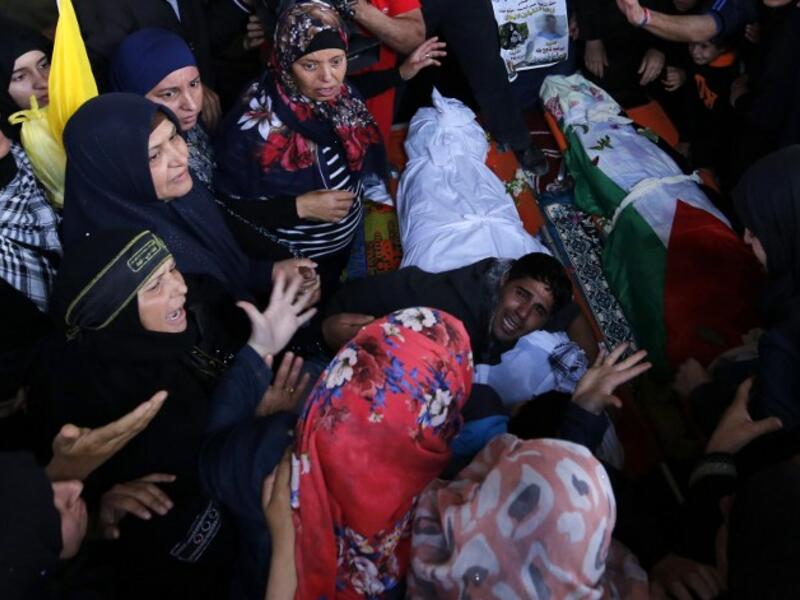 Palestinians mourn over the bodies of Maram Abu Ismail, 23, and her brother Ibrahim Taha, 16, who were shot dead by Israeli police last month at the Qalandiya checkpoint, during their funeral in the West Bank village of Qatanna, on May 23, 2016. (AFP/Abbas Momani)