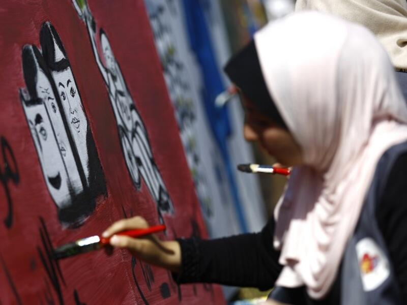A Palestinian art student paints as she takes part in a festival marking the World Mental Health Day on October 11, 2016 in Gaza City. (AFP/Mohammed Abed)