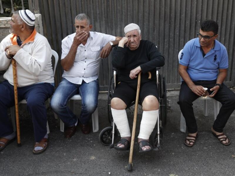 Members of the Shamasneh family sit outside their home after being evicted (Ahmad Gharabli/AFP)