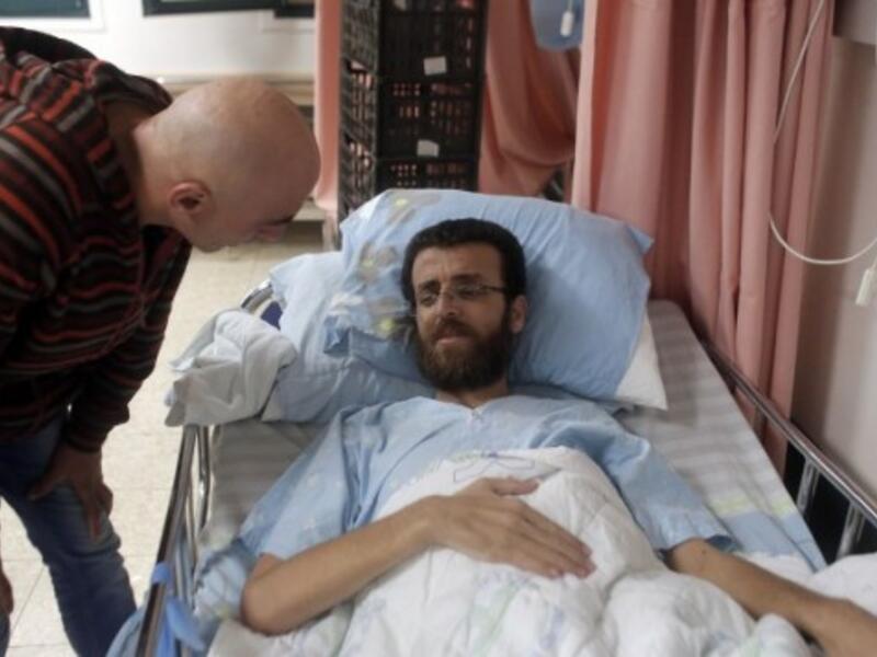 Mohammed al-Qiq, a Palestinian prisoner who carried out hunger strike, talks to a man in a hospital in the northern Israeli town of Afula on February 5, 2016. (AFP/Ahmad Gharabli)