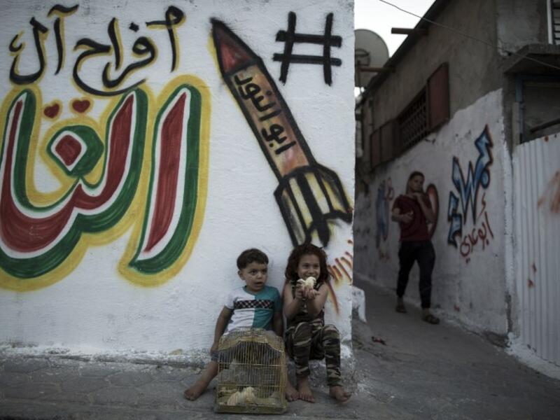 Palestinian children play with chicks in the streets in Jabalia refugee camp, in the northern Gaza Strip, on May 14, 2017 one day before the marking of the 69th anniversary of the "Nakba." (AFP/Mahmud Hams)