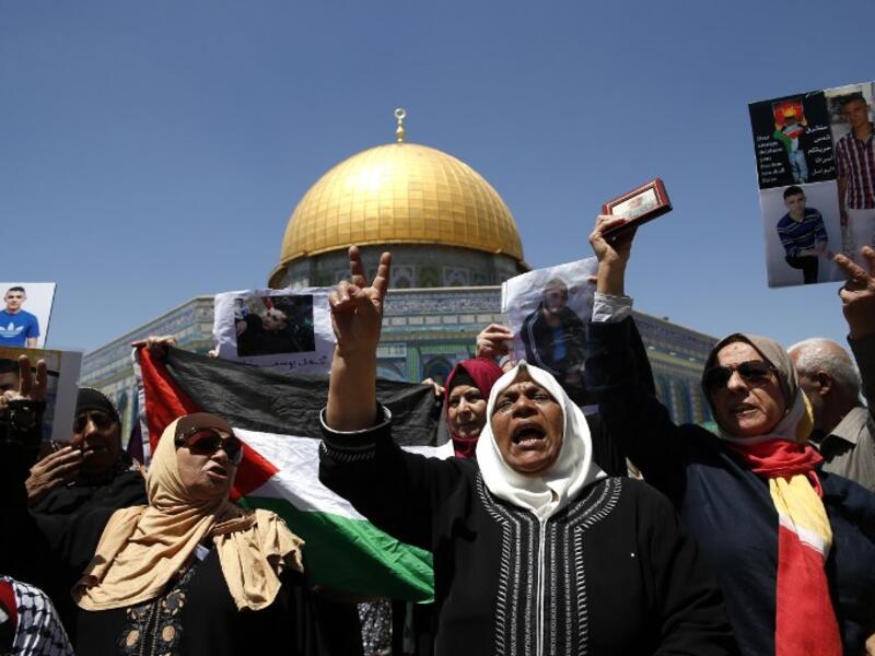 Families of Palestinians imprisoned in Israeli jails demonstrate outside the Dome of the Rock at the Al-Aqsa mosque compound in Jerusalem's Old City on April 28, 2017. (AFP/Ahmad Gharabli)