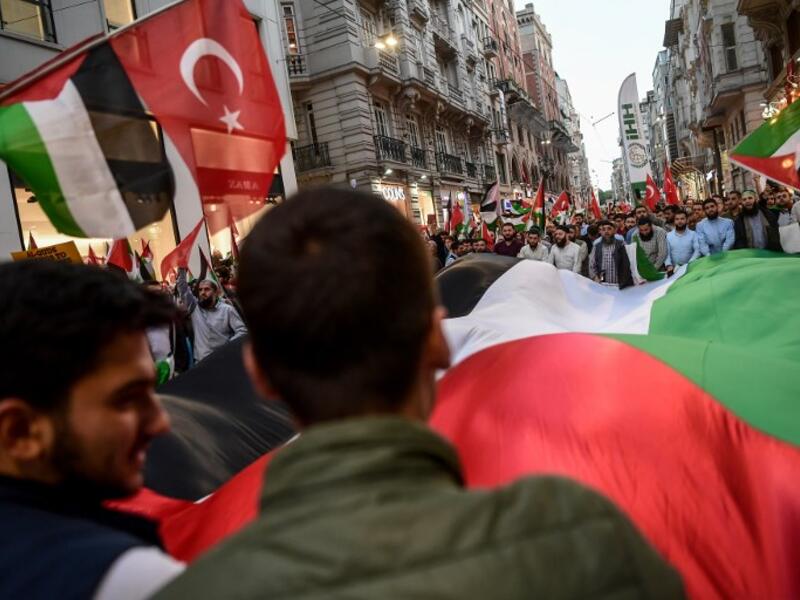 Protesters march as they wave a giant Palestinian flag and also Palestinian flags at the Istikilal avenue in Istanbul on May 14, 2018 during a demonstration against US President's decision to move the US embassy from Tel Aviv to Jerusalem. OZAN KOSE / AFP
