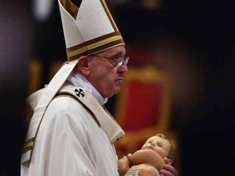 Pope Francis carries the statue of baby Jesus during a mass on Christmas eve marking the birth of Jesus Christ on December 24, 2015 at St Peter's basilica in Vatican. (AFP)