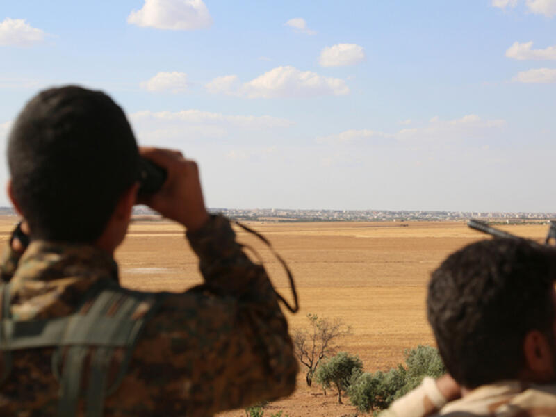 SDF fighters look at the Syrian town Manbij (AFP/File) 